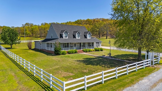 country-style home with a front lawn, covered porch, and a rural view