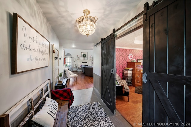 corridor with ornamental molding, dark tile flooring, a chandelier, and a barn door