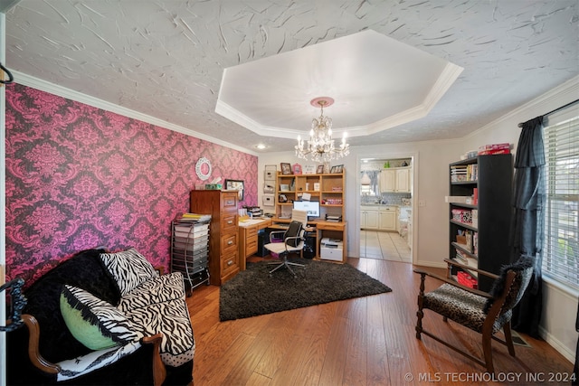 home office featuring light hardwood / wood-style flooring, a chandelier, crown molding, and a tray ceiling