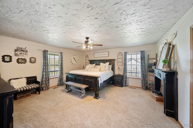 carpeted bedroom with a textured ceiling and ceiling fan