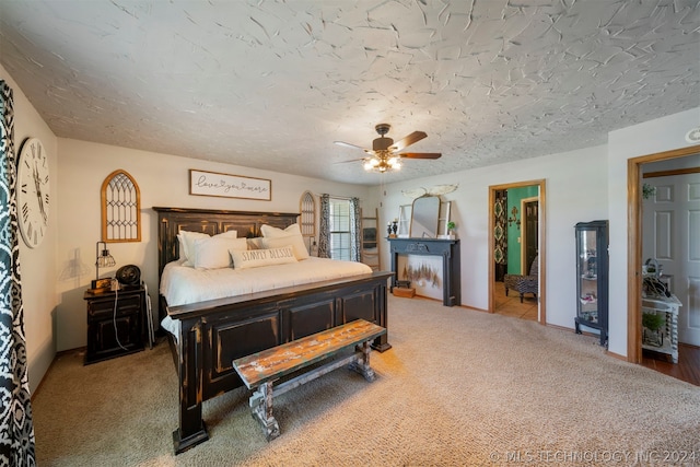 bedroom with light carpet, ceiling fan, and a textured ceiling