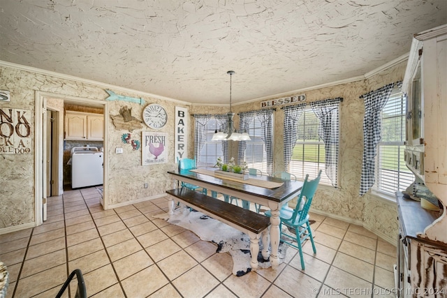 unfurnished dining area featuring a notable chandelier, washer / dryer, light tile flooring, and ornamental molding