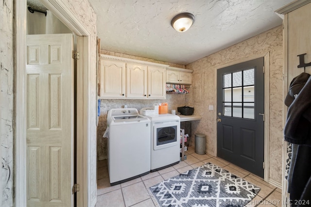 laundry room featuring cabinets, light tile floors, and washer and dryer