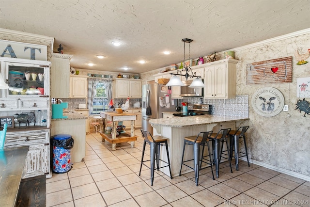 kitchen with appliances with stainless steel finishes, a kitchen bar, backsplash, ornamental molding, and pendant lighting