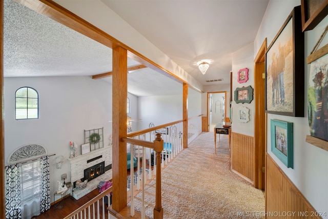 hall with lofted ceiling with beams, carpet floors, and a textured ceiling