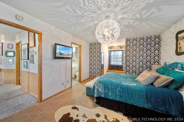 bedroom featuring ensuite bath, an inviting chandelier, and light colored carpet