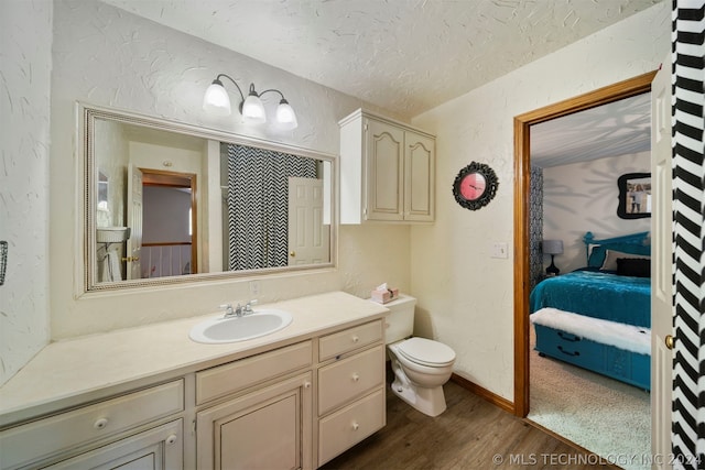 bathroom featuring toilet, vanity, and hardwood / wood-style floors