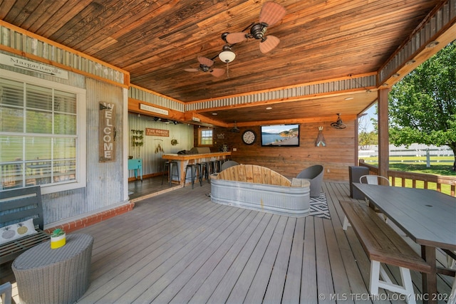 deck featuring ceiling fan and exterior bar