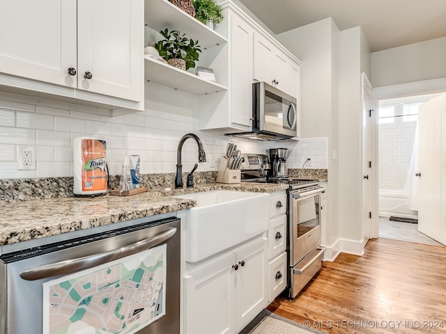 kitchen with light hardwood / wood-style flooring, wine cooler, white cabinetry, appliances with stainless steel finishes, and light stone counters