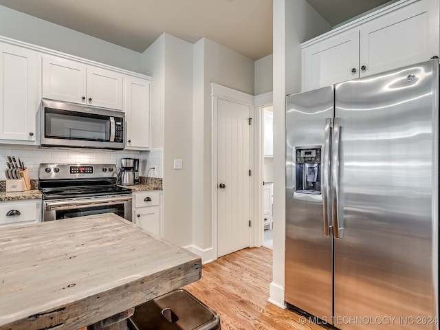 kitchen featuring light stone countertops, white cabinetry, and stainless steel appliances