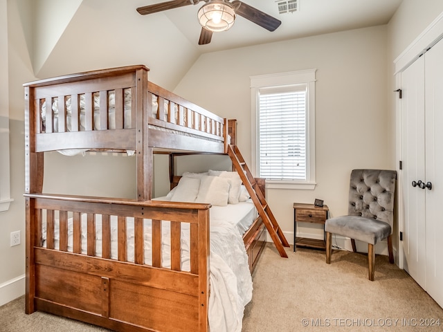 bedroom featuring light carpet, a closet, vaulted ceiling, and ceiling fan