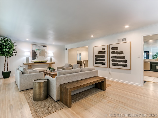 living room with crown molding and light wood-type flooring