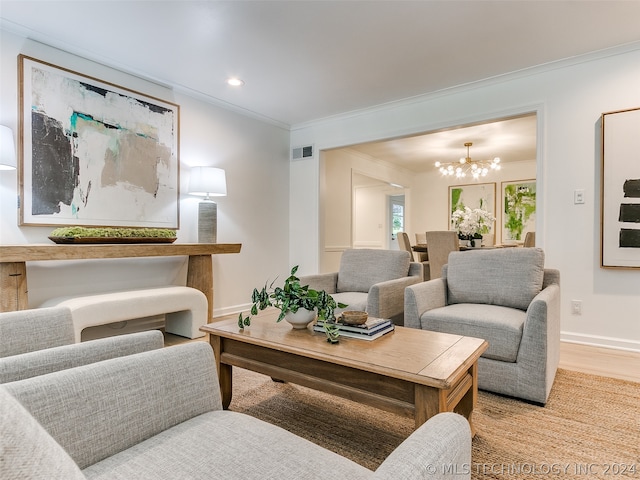 living room featuring ornamental molding, light hardwood / wood-style floors, and an inviting chandelier