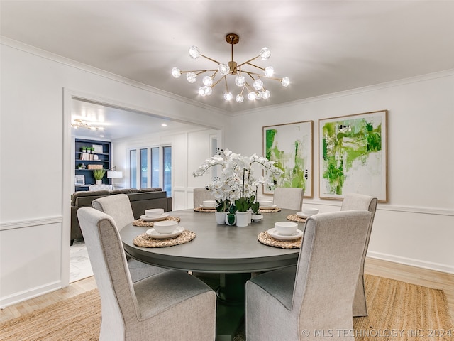 dining room featuring an inviting chandelier, light wood-type flooring, and ornamental molding