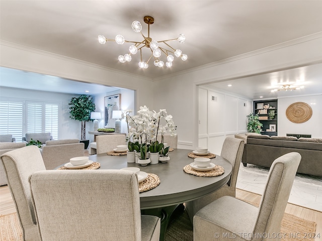 dining space featuring a notable chandelier, crown molding, and light wood-type flooring