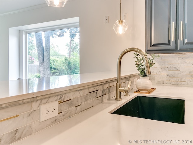 details featuring backsplash, sink, and ornamental molding