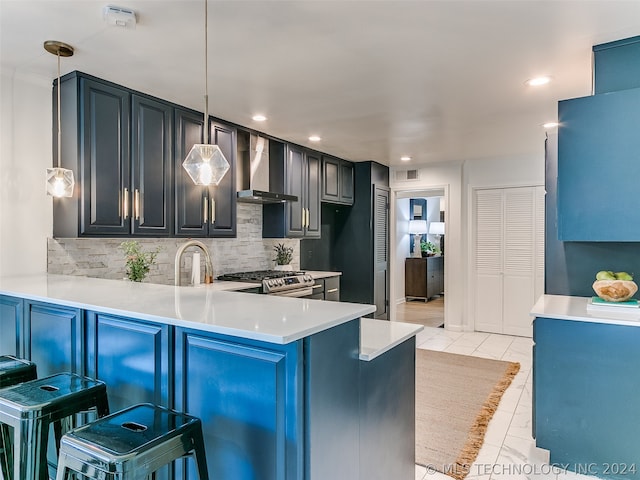 kitchen with a breakfast bar, light tile flooring, wall chimney range hood, tasteful backsplash, and decorative light fixtures