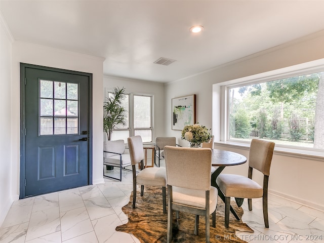 dining room with ornamental molding and light tile floors