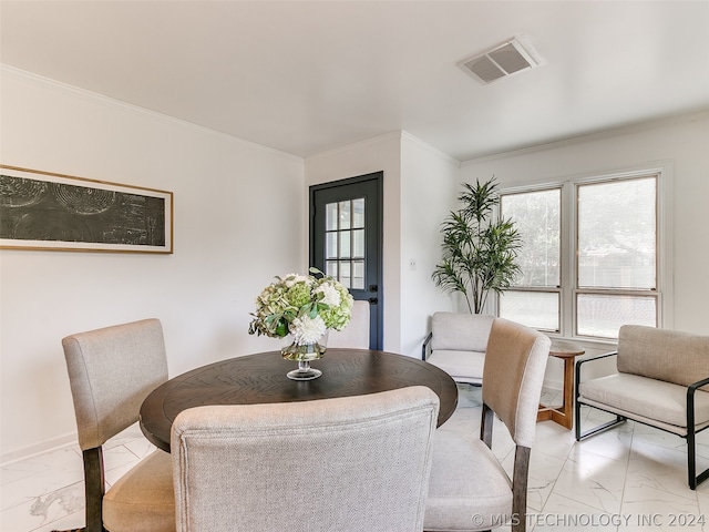 dining room featuring crown molding and light tile floors