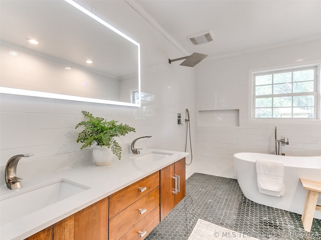 bathroom featuring a washtub, double vanity, tile walls, and tile floors