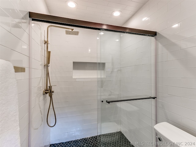 bathroom with an enclosed shower and toilet