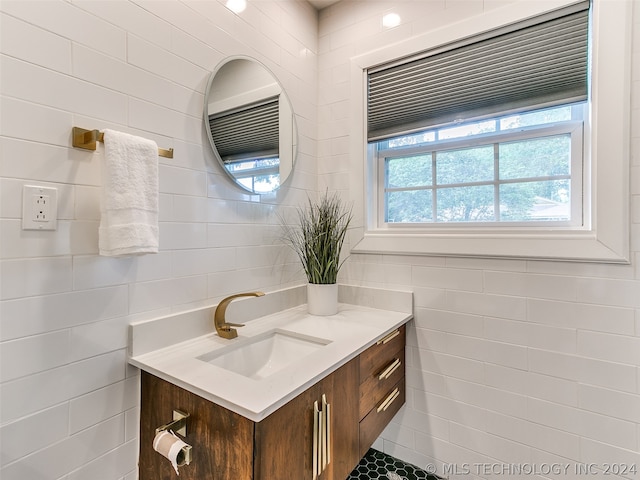 bathroom with tile walls, plenty of natural light, and vanity