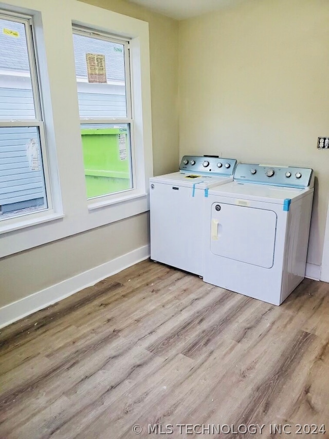 laundry area with washing machine and dryer, plenty of natural light, and hardwood / wood-style floors