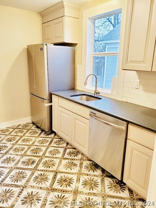 kitchen featuring sink, a wealth of natural light, light tile flooring, and stainless steel dishwasher