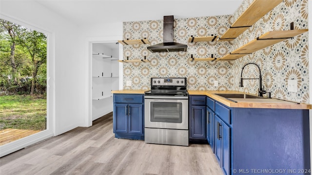 kitchen featuring wood counters, wall chimney range hood, stainless steel range with electric cooktop, and light hardwood / wood-style flooring