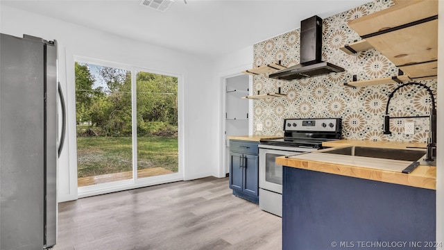 kitchen featuring sink, light hardwood / wood-style flooring, stainless steel appliances, wall chimney exhaust hood, and wood counters