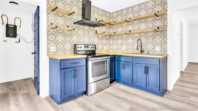 kitchen with blue cabinets, light hardwood / wood-style floors, stainless steel range with electric stovetop, and wall chimney exhaust hood