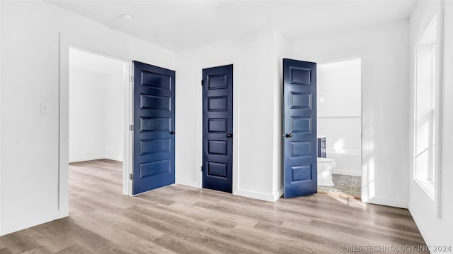 interior space with connected bathroom and hardwood / wood-style floors