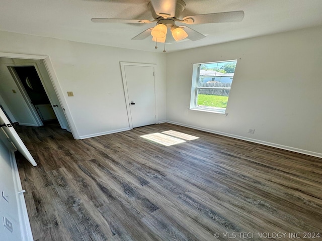 unfurnished bedroom with a closet, dark wood-type flooring, and ceiling fan