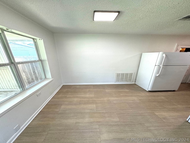 interior space featuring light tile patterned flooring and a textured ceiling