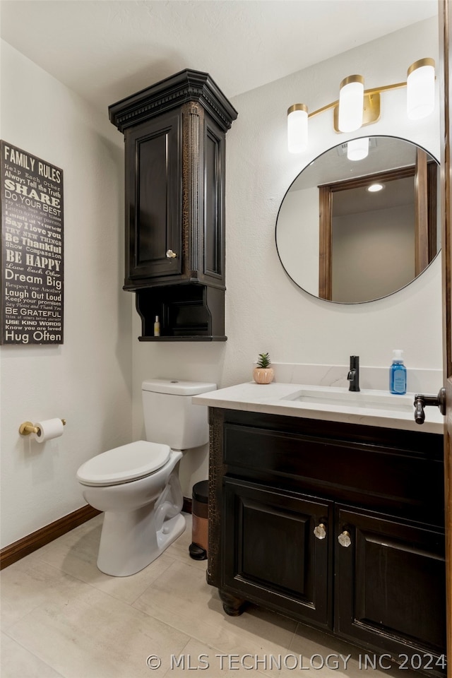 bathroom with toilet, tile flooring, and vanity