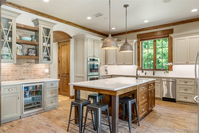 kitchen featuring beverage cooler, tasteful backsplash, a kitchen breakfast bar, stainless steel appliances, and a kitchen island with sink