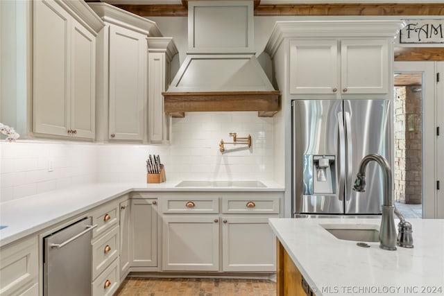 kitchen featuring backsplash, sink, appliances with stainless steel finishes, and light stone counters