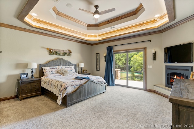 bedroom with carpet, a raised ceiling, crown molding, and access to exterior