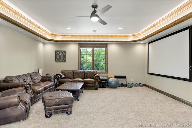 home theater room featuring ornamental molding, carpet flooring, and a tray ceiling