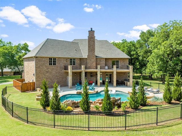 back of property featuring a patio area, a lawn, and a fenced in pool