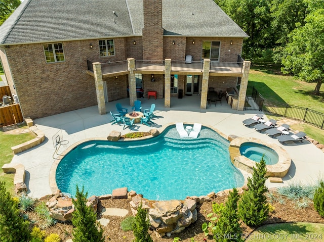 view of swimming pool with a patio area, a lawn, and an in ground hot tub