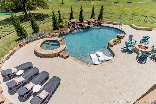 view of pool with a patio area, a yard, pool water feature, and an in ground hot tub