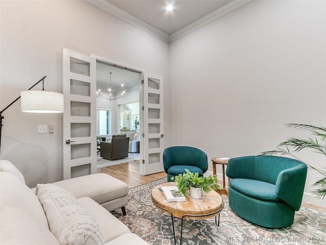 living room featuring a chandelier, built in features, wood-type flooring, and crown molding