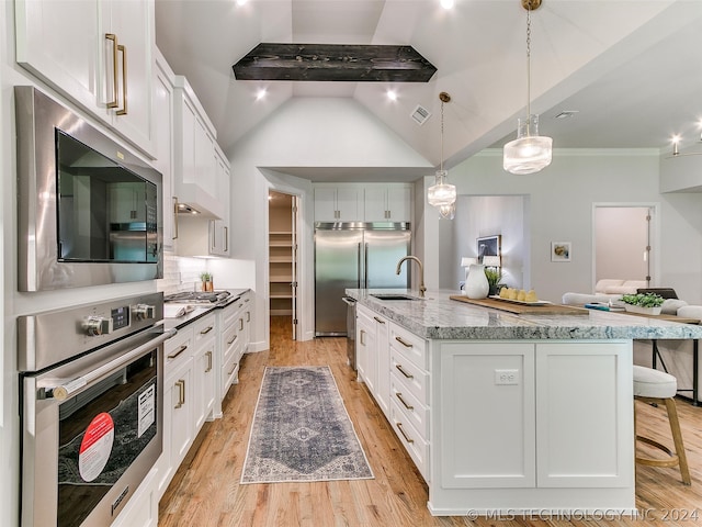 kitchen with an island with sink, white cabinetry, and light wood-type flooring