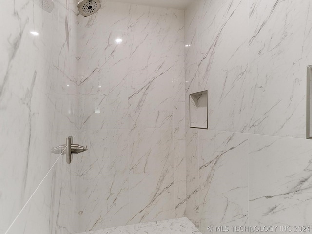 interior details with a tile shower