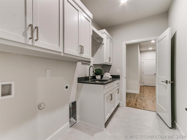 laundry area with cabinets, sink, light tile flooring, and electric dryer hookup