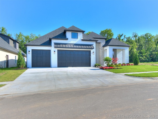 view of front of home featuring a garage and a front lawn