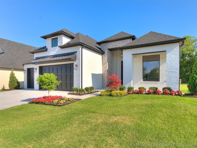 view of front of home with a front yard and a garage