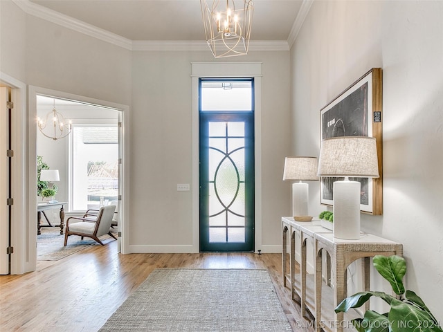 entryway with crown molding, a healthy amount of sunlight, a chandelier, and hardwood / wood-style floors