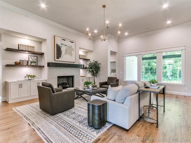 living room featuring a notable chandelier, ornamental molding, light hardwood / wood-style floors, and a fireplace